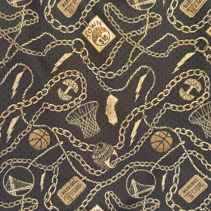 The All Gold Forever Shorts by Other showcase a bold black fabric adorned with gold chain links, lightning bolts, basketballs, hoops, bridges, and Golden State Warriors logos—including “The Town” and “Warriors Champions” motifs—for a vibrant sports-inspired look reminiscent of the Warriors x Oaklandish Town Collection.