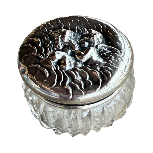 Decorative glass container with silver lid featuring angel design on a white background