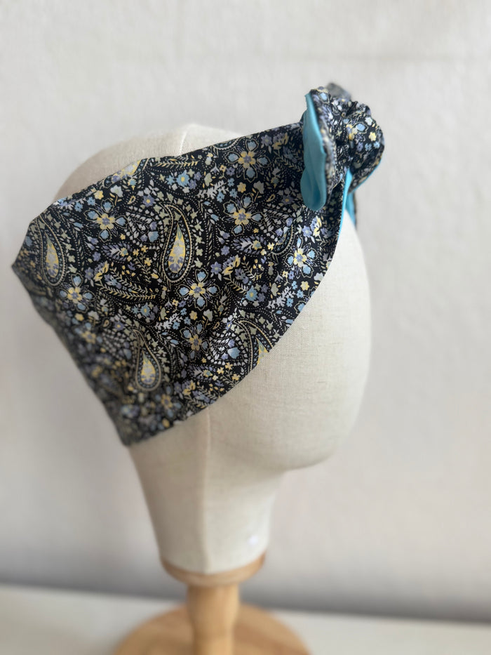 Floral paisley headband on a mannequin head against a plain background