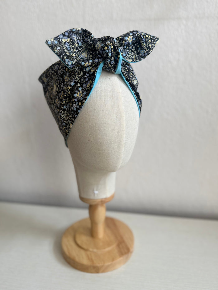 Floral paisley headband on a mannequin head against a plain background