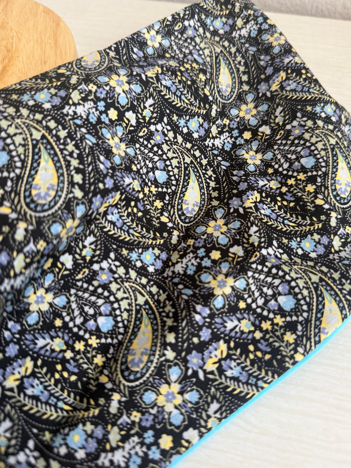 Floral paisley headband on a mannequin head against a plain background