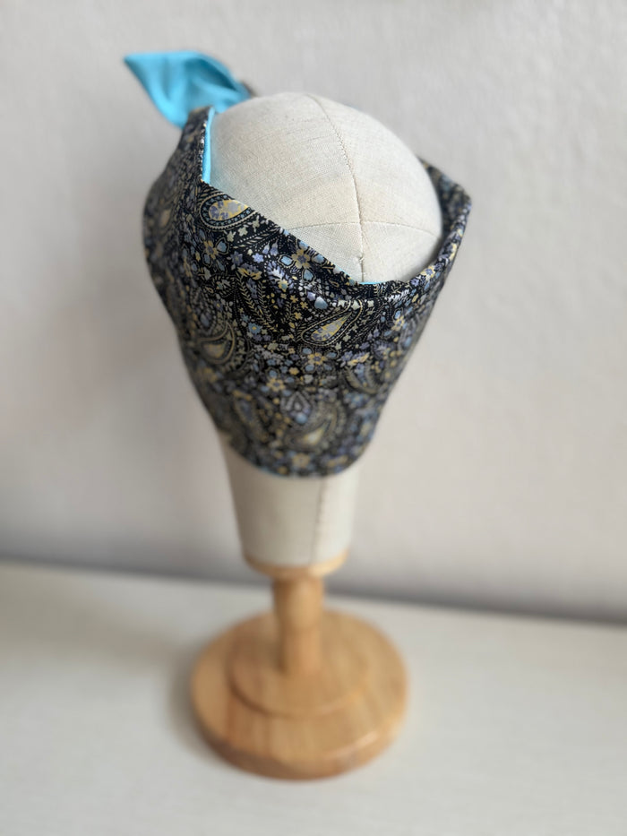 Floral paisley headband on a mannequin head against a plain background