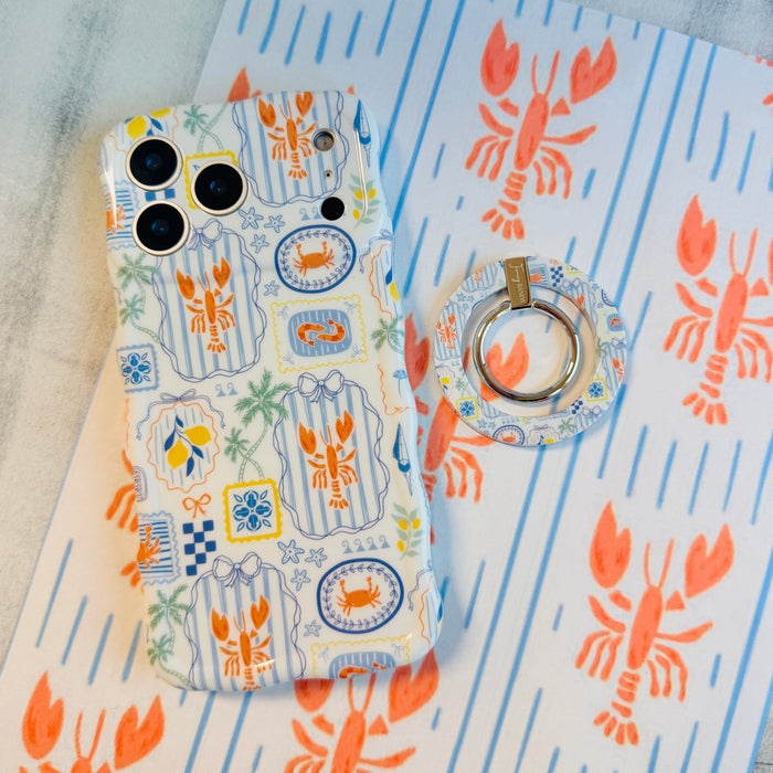 Coastal Catch MagSafe phone grip ring with orange lobster, blue stripes, and nautical postage stamp pattern compatible with iPhone and Samsung