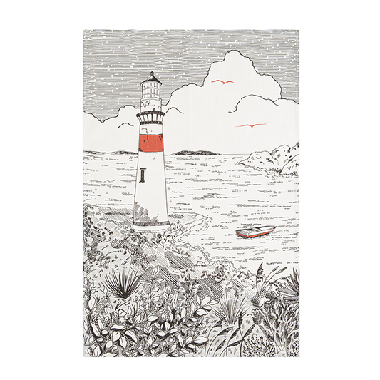 A black and white image of a tea towel with an illustration of a lighthouse, surrounded by foliage and a body of water in the background.