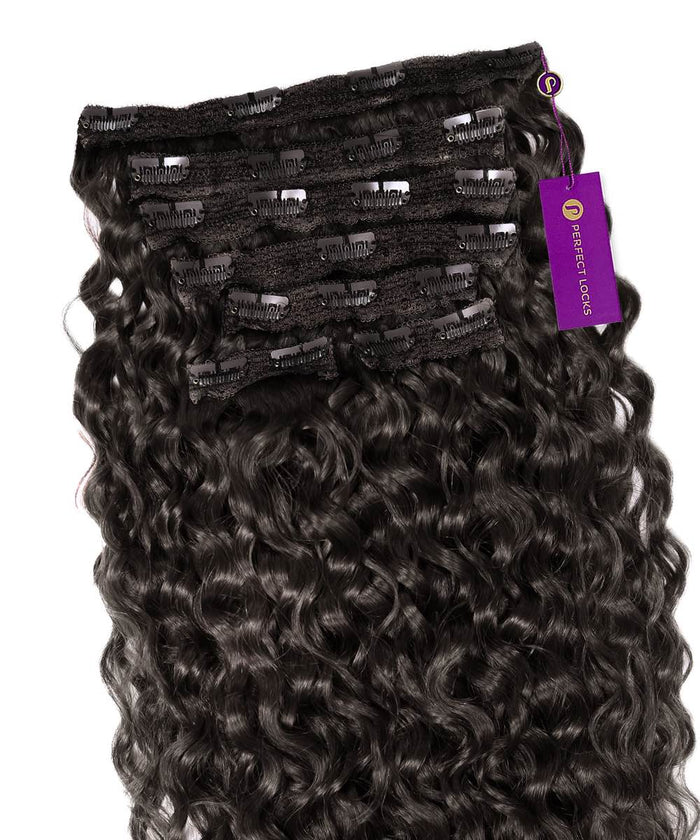 A stack of Curly Classic Clip-In Hair Extensions in Natural Black  from Perfect Locks, with a purple Perfect Locks tag attached.#color_natural-black-(1B)
