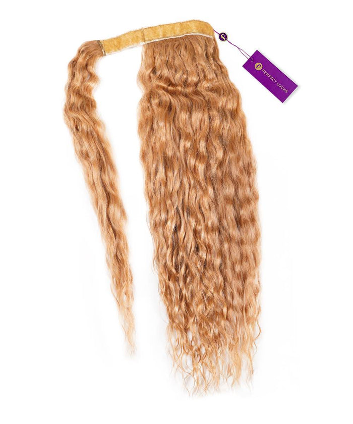 A single Curly Clip-In Ponytail Extension by Perfect Locks in Honey Blonde  with a yellow band, purple tag, and soft waves.#color_honey-blonde-(27)