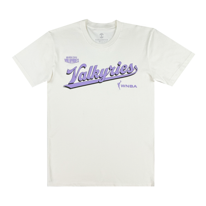 A white GSV organic cotton tee features "Golden State Valkyries" in large purple script across the chest, a small player silhouette and "WNBA" logo on the right, with "Golden State Valkyries Retro Script Tee" above in smaller purple text.