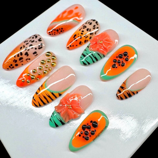 A set of 10 glossy press-on nails displayed on a white square card against a black background. The nails feature various designs including leopard print, tiger stripes, watermelon slices, gold studs, and coral flower accents.
