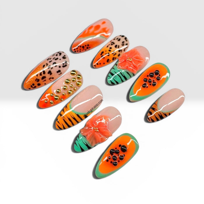 Ten almond-shaped press-on nails with vibrant tropical and animal-inspired designs, including orange and black stripes, leopard print, green and orange patterns, and a 3D orange flower accent, displayed on a light gray background.