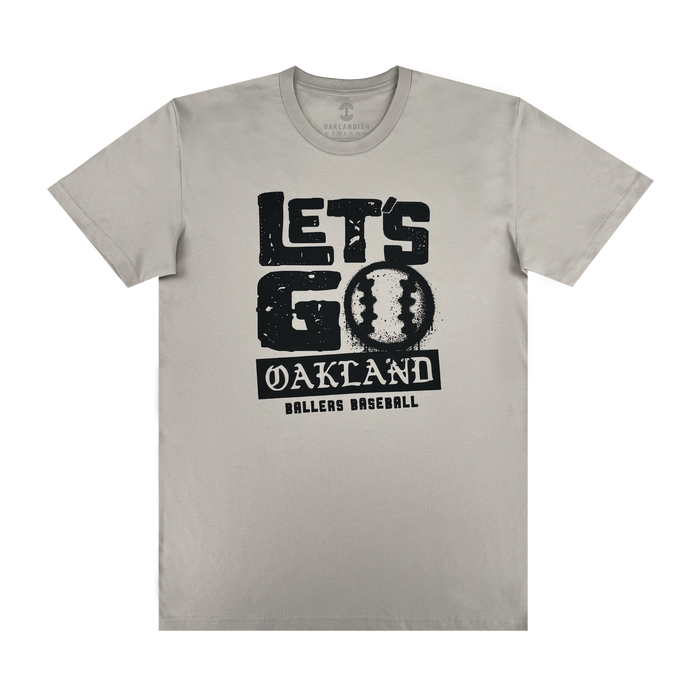 The Let's Go Oakland Tee by Oakland Ballers features bold "LET'S GO" text above a baseball graphic as the "O," with distressed "OAKLAND BALLERS BASEBALL" below, celebrating Pioneer League pride in the East Bay.