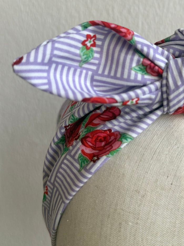 Floral headband on a mannequin head against a plain background