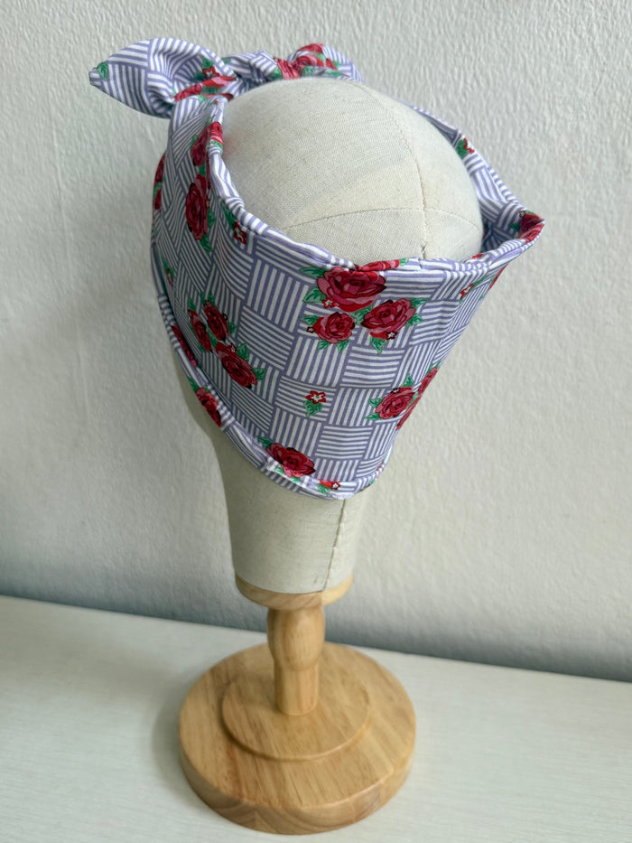 Floral headband on a mannequin head against a plain background