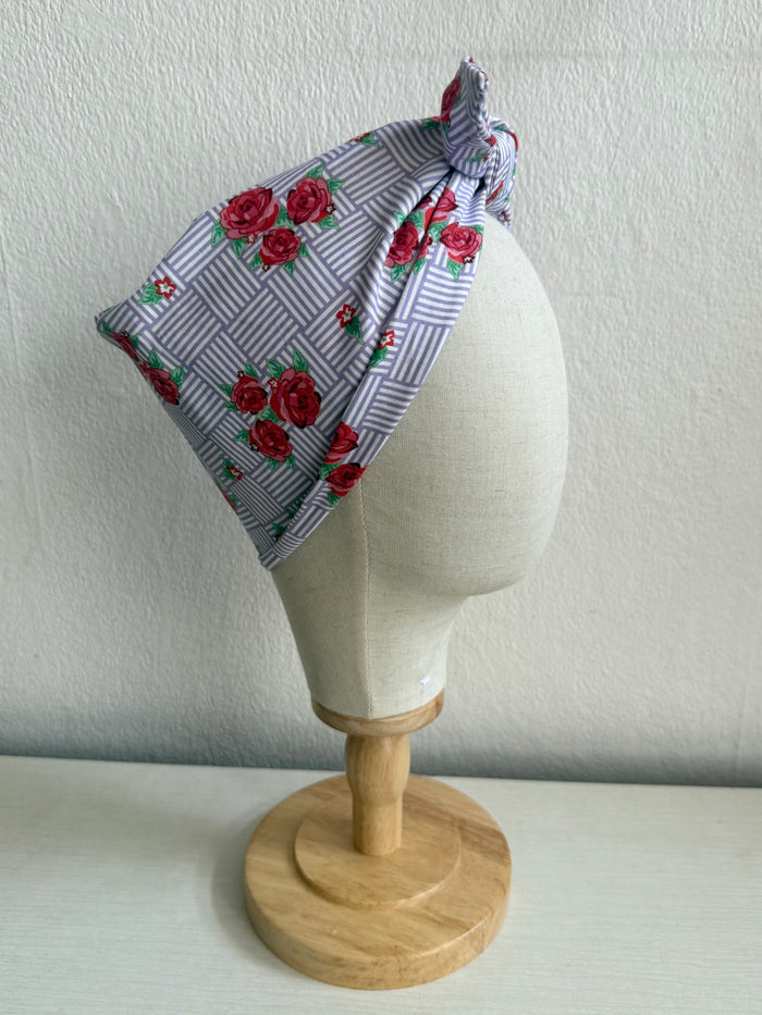 Floral headband on a mannequin head against a plain background
