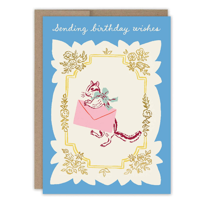 Birthday card with a cat holding a pink envelope and floral decorations on a blue background.