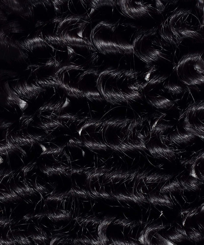 Close-up of tightly coiled, shiny black curls with defined ringlets and texture, showcasing Perfect Locks Tight Curly hair extensions.